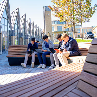 Students sitting outside. Links to Gifts by Estate Note